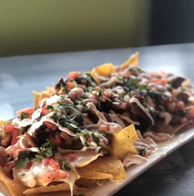 Nachos BBQ Pork · Shredded pork cooked in our homemade BBQ souce topped with mixed cheese, white cheese dip, pico de gallo and sour cream