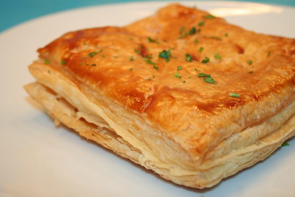 Tiropita · Cheese pie with feta and herbs baked in phyllo dough. Add tzatziki for an additional charge. 