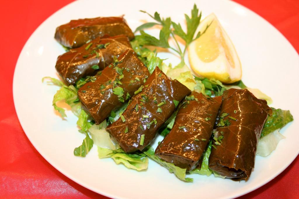 Dolmades · Stuffed grape leaves with rice, herbs and spices. 