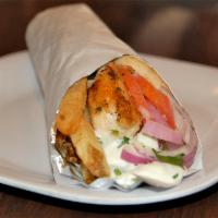 Pork Souvlaki Pita Sandwich · Tender cubes of grilled pork seasoned with herbs. Topped with tomato, red onion, fresh cut f...