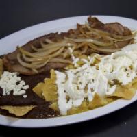 Chilaquiles verdes con Bistec · Green salsa Chilaquiles. Served with grilled thin steak and onions.