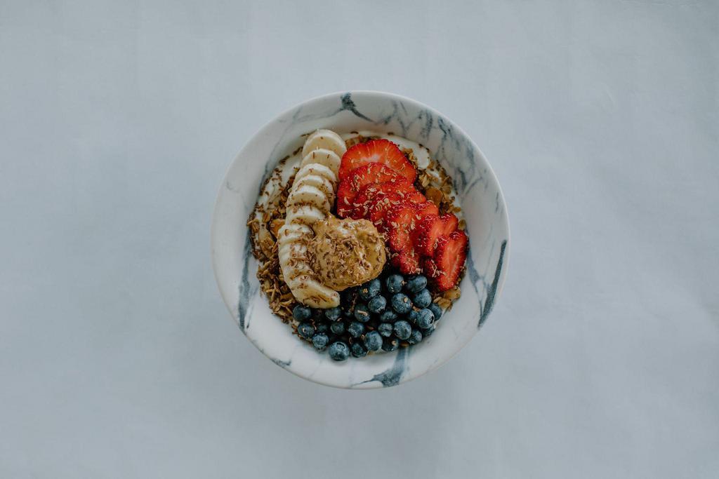 Granola Bowl · Granola, honey yogurt, peanut butter, bananas, blueberries, strawberries, and shaved chocolate.