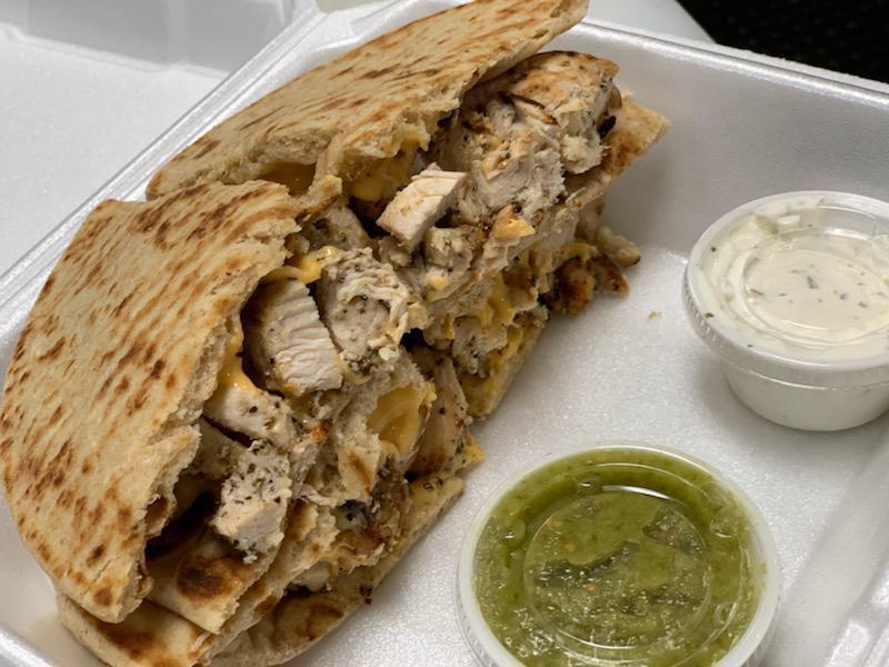 Chicken Melt · Our delicious all-natural charbroiled chicken breast sandwiched between two pita's with choice of cheese served with tzatziki and our own green salsa, green salad and choice of side