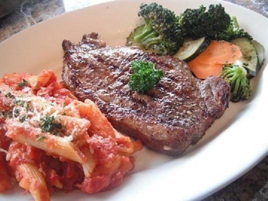 Rib Eye Steak · Hand-cut, seasoned tender grilled rib eye. Served with vegetables, pasta, bread and butter.