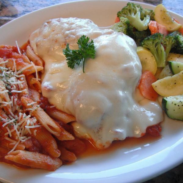 Chicken Parmigiana · Breaded chicken with marinara sauce and topped off with cheese. Served with vegetables, pasta, bread and butter.