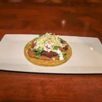 Tostada · An open faced hard shell corn tortilla with beans, lettuce, tomato, sour cream, cheese and y...