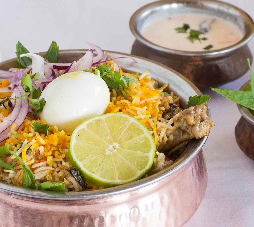 Hyderabadi Chicken Biryani · Chicken cooked in basmati rice with special herbs and spices. Your choice of vegetables, chicken or lamb cooked with spicy Basmati rice. Seved with raita and sauce.