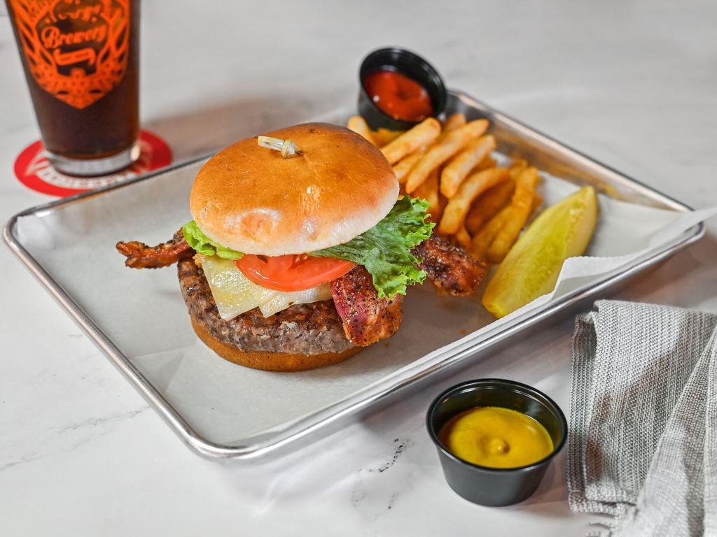 The Cowboy Burger · Our chargrilled chuck, brisket, and short rib burger with avocado crema, pepper jack cheese, peppercorn candied bacon, fried Jalapenos, BBQ sauce, lettuce, and tomato on a brioche bun.
