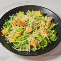 Americon Caesar · Romaine lettuce tossed in Caesar dressing with shredded Parmesan and croutons.