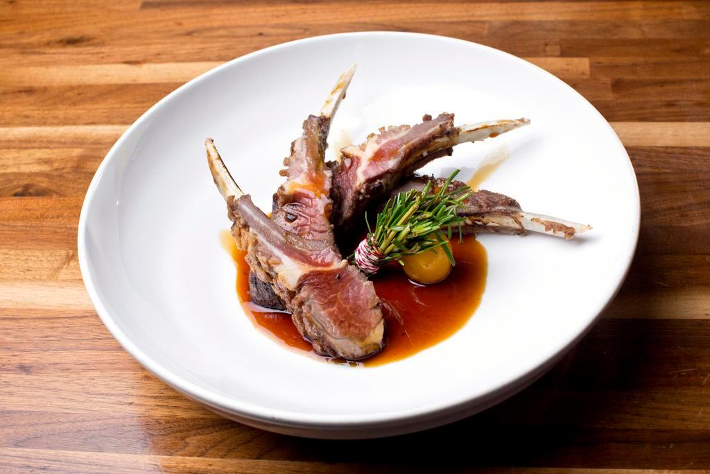 Roasted Rack of Lamb · Frenched rack of lamb with white wine, rosemary and truffle au jus. Gluten free.