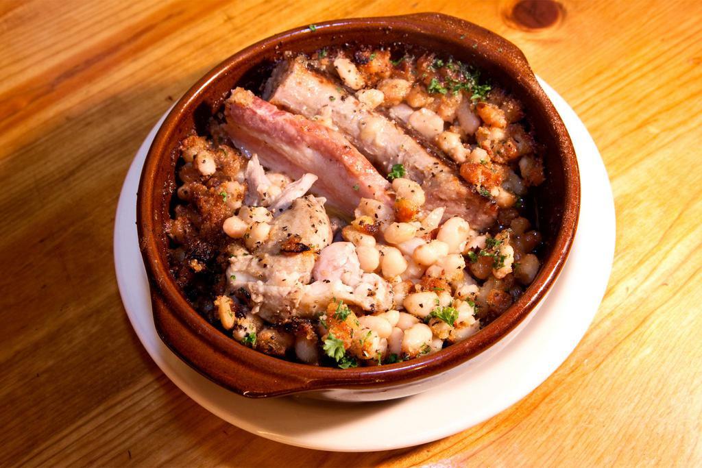 Kassulet Toulousain de la Maison · Signature winter dish. Served year round upon customer request. Cassoulet Toulouse style. My personal recipe cannellini beans, carrots, tomato, garlic, duck confit, slab bacon, and pork sausage all braised with noble duck fat, white stock, and foie gras jus. This very rich dish was served to warriors defending their village.