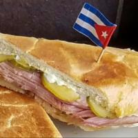 Sandwich Cubano  · Smoked ham, roast pork, Swiss cheese, pickles and mustard. With a slight bit of mayo and but...