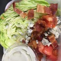 Wedge Salad · Wedge topped with bleu cheese crumbles, bacon, and tomato and house made bleu cheese dressing.