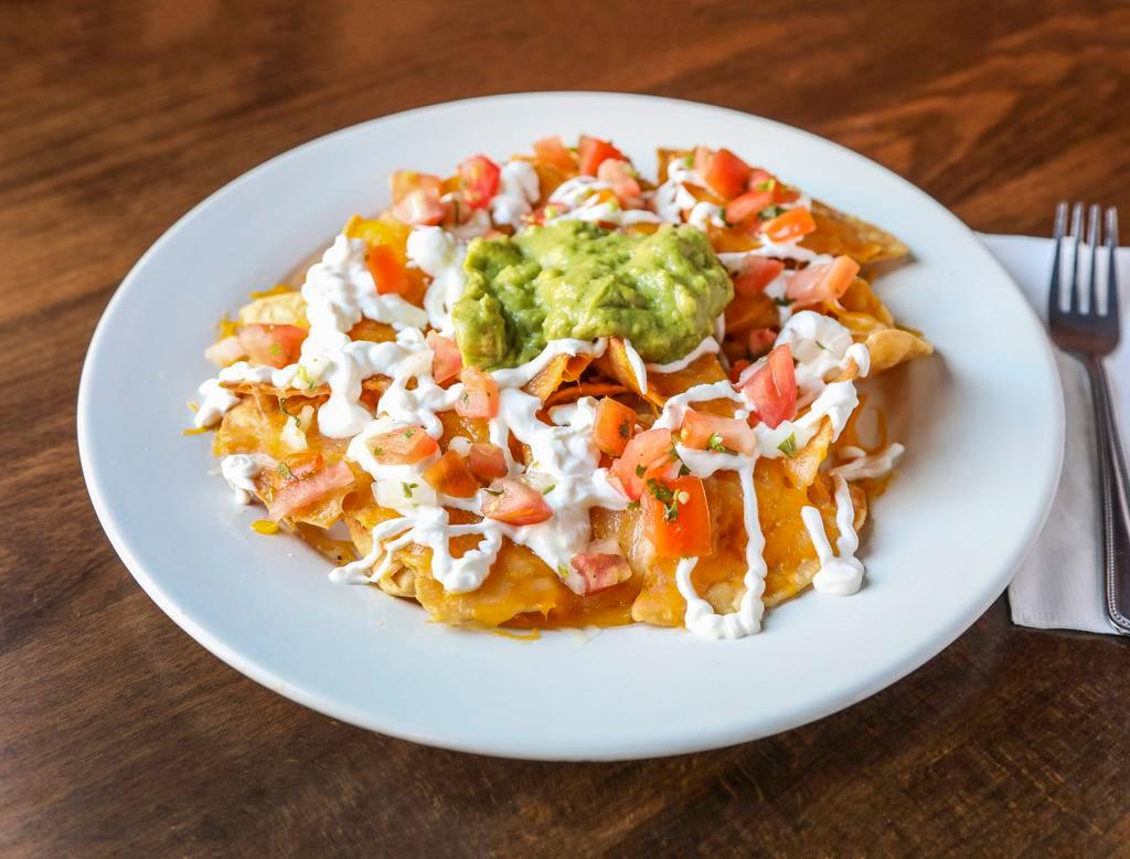 Nachos Supreme · Corn tortilla chips topped with a blend of melted Jack and cheddar cheese choice of beans and meat or vegetable filling.