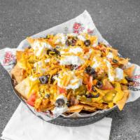 Loaded Nachos · Tortilla chips topped with cheddar cheese, sour cream, black olives, tomatoes, jalapenos, an...