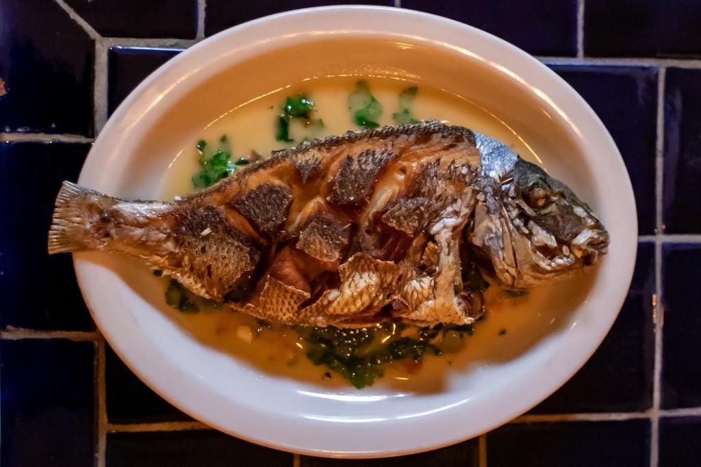 Pescado · Whole fried dorado fish, baby kale and mojo de ajo