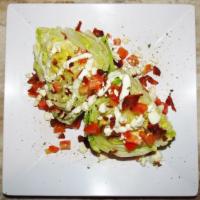 Wedge Salad · Crisp iceberg wedge topped with diced tomatoes, crisp bacon and crumbled bleu cheese.