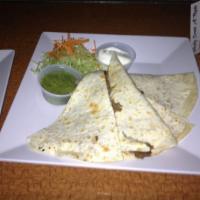 Steak Fajita Quesadilla · Crispy flour tortilla served with shaved steak, sauteed onions and peppers, covered with Mon...