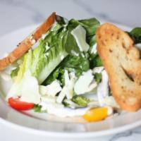Caesar Salad · Baby romaine, shaved Parmesan, croutons  and lemon garlic dressing.