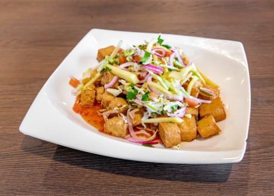Sweet Chili Tofu · deep-fried soft tofu tossed with sweet chili sauce and topped with fresh mango slaw (mango, red onions, cilantros, tomatoes and cabbage). Gluten Free. 