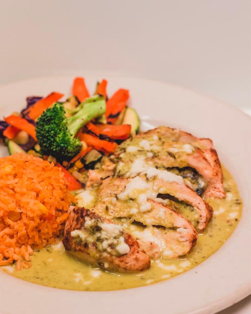 Chicken Poblano · Stuffed chicken breast with poblano pepper strips, mushrooms onions topped with poblano cream sauce and queso fresco.