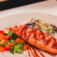 BBQ Salmon · Grilled salmon with chipotle BBQ, over sauteed vegetables and cole slaw.