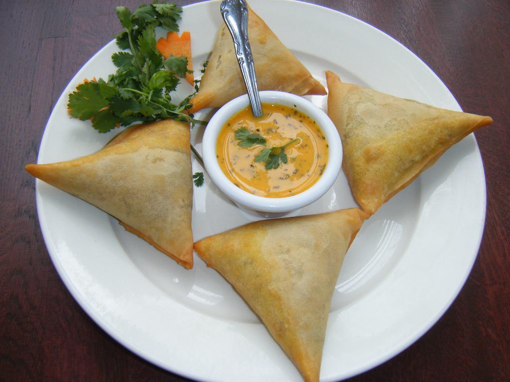 Chicken Samosas · Triangular puffed pastry, spiced with paach-foron. Stuffed with minced chicken, sweet corn, and potatoes.