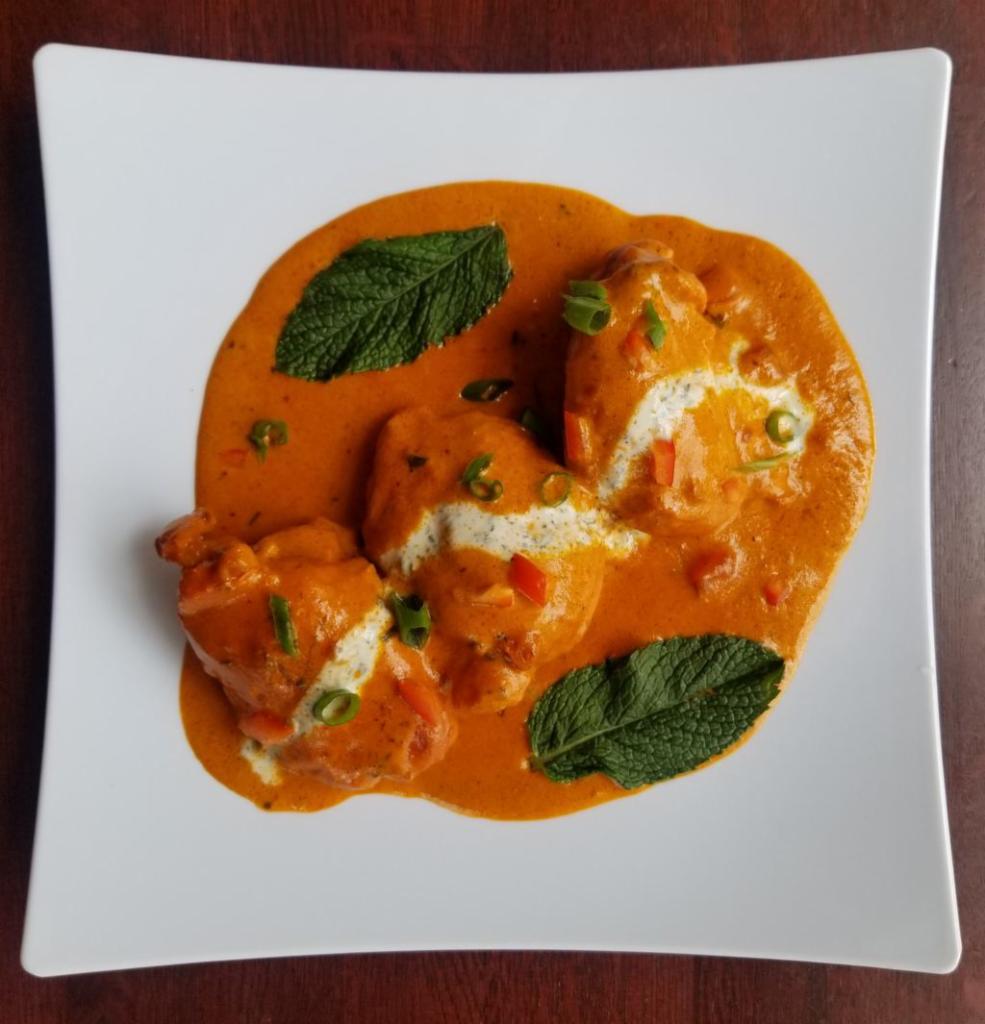 Butter Chicken · Chicken dark meat marinated in a blend of yogurt and very mild tandoori spices, then baked in clay oven and cooked with cream and our chef’s special spices, garnished with dried methi leaves (fenugreek) and butter.