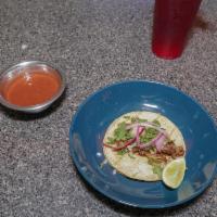 taco de carnitas · shredded pork topped with onions cilantro hot sauce on the side