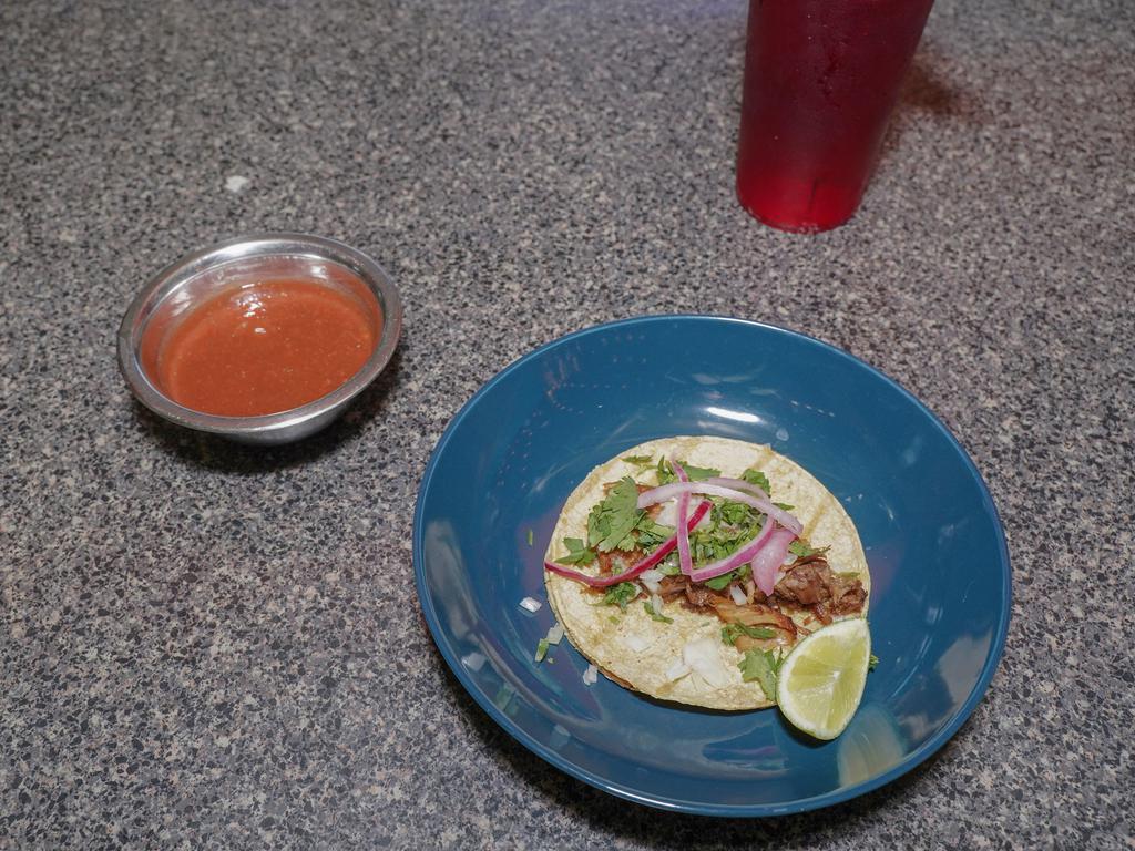 taco de carnitas · shredded pork topped with onions cilantro hot sauce on the side