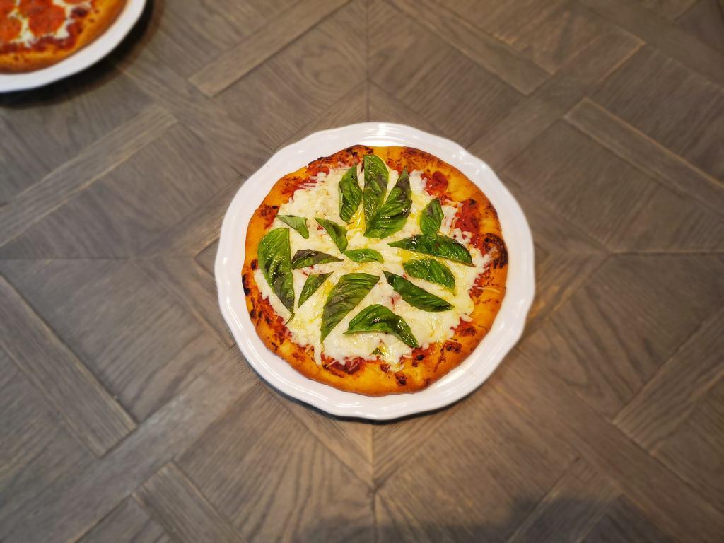 Margherita Pizza · House Made Sauce, Mozzarella, Parmigiano Reggiano and Fresh Basil Served on a 10