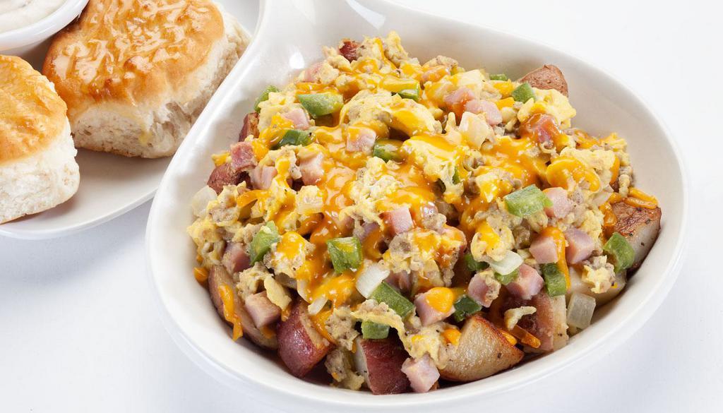 Farmer's Skillet · Two scrambled eggs, ham, crumbled sausage, onions, bell peppers, on a bed of seasoned home fries and topped with cheddar cheese.			