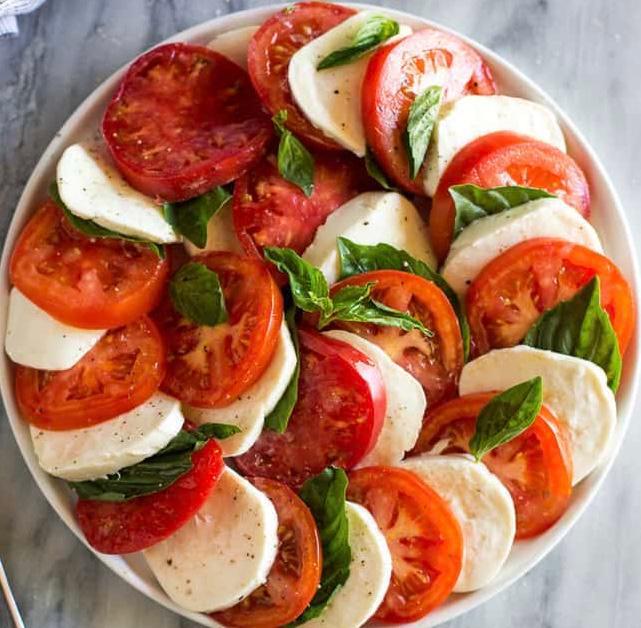 Mozzarella Caprese · Slices of fresh mozzarella and tomatoes, topped with basil, homemade balsamic vinaigrette and olive oil.