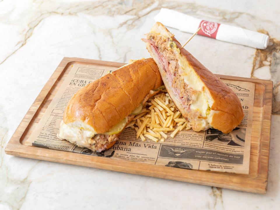 Cubano Sandwich · A Cuban classic served with ham, roasted pork, swiss cheese, pickles and mustard. Served in a perfectly pressed Cuban bread
