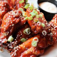 Lawrence Ave Wings · Signature chicken wings tossed in our sweet and spicy Lawrence Ave sauce. Topped with green ...
