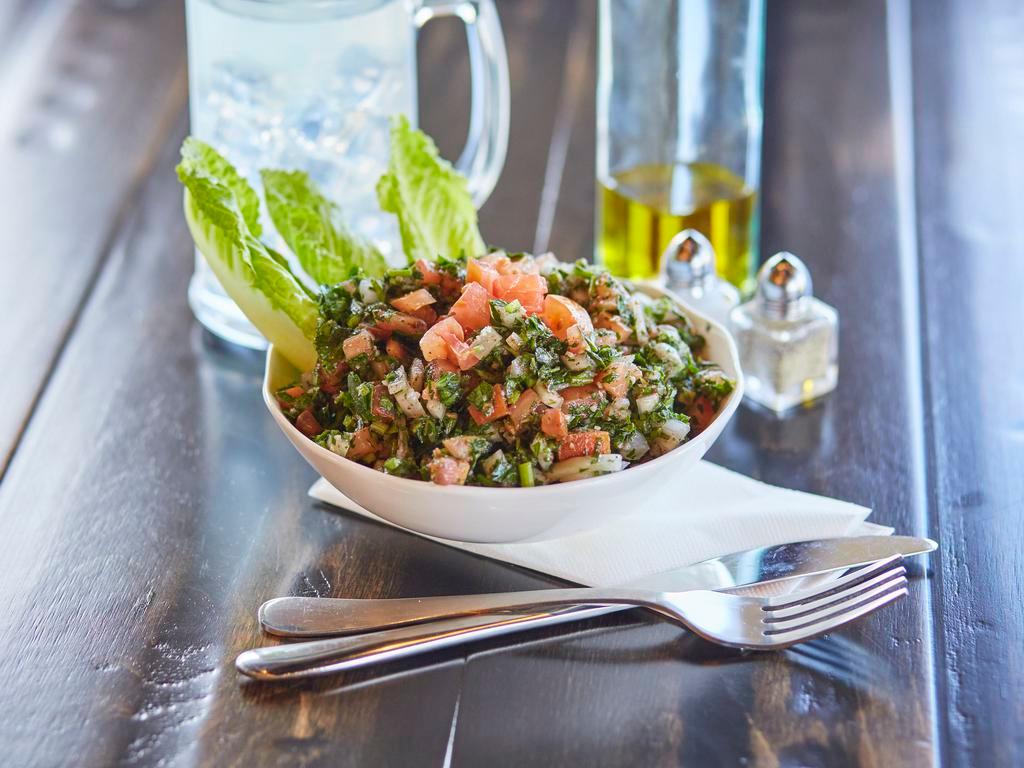 Tabbouleh Salad · A fresh mix of very finely chopped parsley, tomatoes, fresh mint, cracked wheat, and diced onions tossed in fresh lemon juice, and organic extra virgin olive oil. Vegan. Vegetarian.