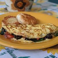 Greek Omelet Breakfast · Spinach, black olives, red onions, diced tomatoes, garlic and feta cheese. Includes a choice of bread.