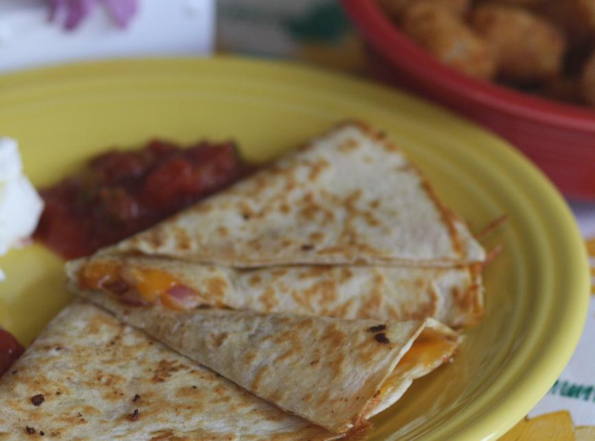 Quesadilla Lunch · Grilled tortilla filled with chicken, caramelized onion and melted cheddar. Served with sour cream and mild salsa.
