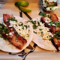 Smoked Pork Belly Tacos · Smoked pork belly, Cotija cheese, cilantro and fresh lime