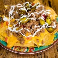 Super Nachos · Tortilla chips, queso, ground beef, onions, tomatoes, jalapenos and sour cream.