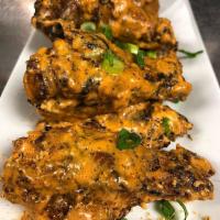 Lucifer Wings · Slow smoked crispy wings with Louisiana hot sauce & blue cheese crumbles