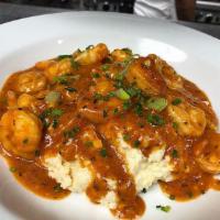 Louisiana Shrimp and Grits Dinner · Sauteed gulf shrimp, plum tomato, roasted garlic & white wine sauce over habanero-goat chees...