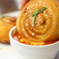 Garlic Knots · Baked garlic knots served with a rustic tomato sauce topped with Pecorino cheese.