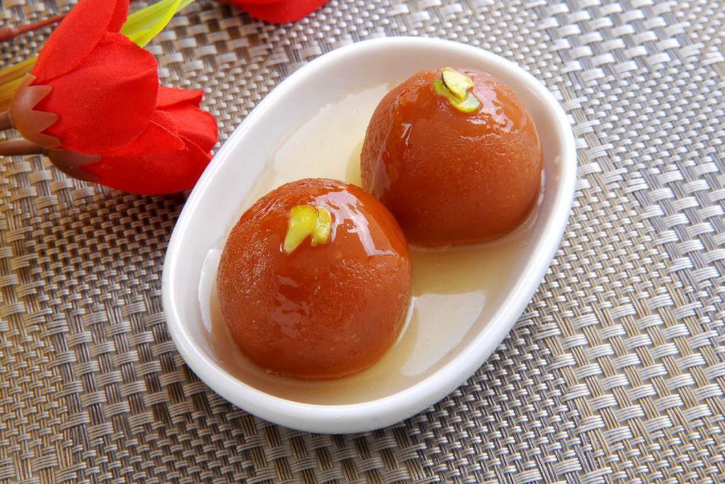 Gulab Jamun · Gulab Jamun is one of India's most popular sweets. Deep-fried dumplings/donuts (3 pieces) made of dried milk are dipped in a cardamom flavored sugar syrup.
