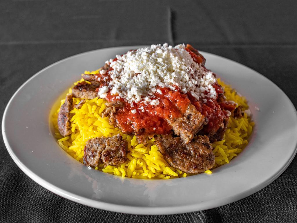 Turkish Gyro · Gyro meat over rice, topped with cooked tomato sauce and served with feta and a side of tzatziki.