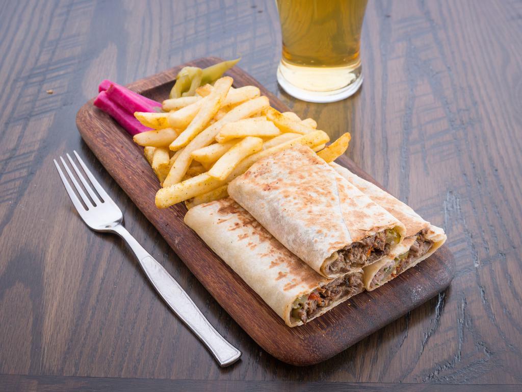 Veal Shawarma Wrap · 100% pure veal meat, spiced and cooked on open flame, with a mix of parsley onions and sumak, tomatoes, tahini and pickled cucumbers. Served with fries, pickled cucumbers, turnip pickles and tahini sauce.