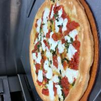Margherita Pizza · Fresh mozzarella, fresh tomatoes and fresh basil, drizzled with extra virgin olive oil.