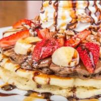 Banana Split Pancakes · One buttermilk, one chocolate pancake topped with bananas, strawberries, pecans, and whipped...