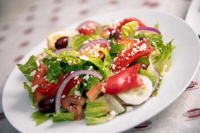 Signature Greek Salad · Fresh romaine lettuce, vine-ripened tomatoes, feta cheese, sliced cucumbers, red onions, Kalamata olives, peppers, and our signature Greek dressing.