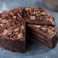 Slice of Traditional Chocolate Fudge Cake · Alternative layers of rich fudgy cake and smooth chocolate cream, covered with chocolate sha...